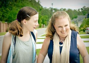 Young girl and woman talking and laughing