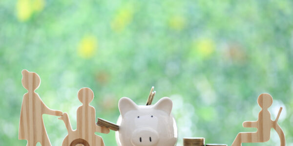 Wooden people with piggy bank