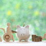 Wooden people with piggy bank