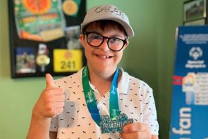 ABLE United account holder with triathlon medal