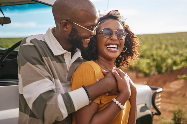 Couple smiling and laughing outside in the sun
