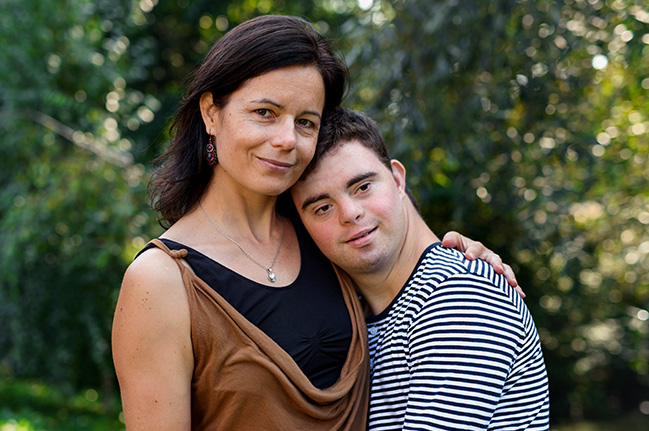 Mother and adult son smiling outdoors