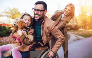 man in a wheelchair with his family