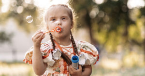 little girl blowing bubbles