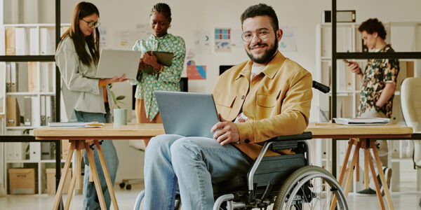 man smiling at work in a wheelchair at home