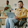 man smiling at work in a wheelchair at home