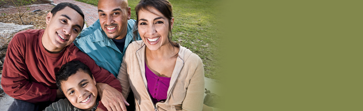 Hispanic family sitting together in a circle and looking up at the camera