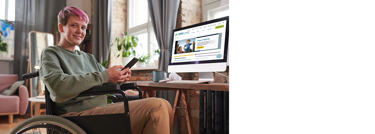 Ambiguously gendered person smiling and holding phone in wheelchair